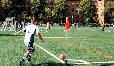 Man playing in a football match doing a corner kick