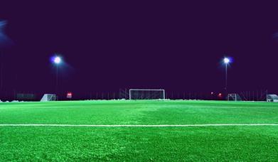 Empty football pitch at night with lights